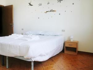 a bedroom with a bed with white sheets and butterflies on the wall at A casa di Titti Arezzo in Arezzo +5 photos