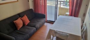 sala de estar con sofá negro y mesa en Delpino Propiedades Portico 914 en Viña del Mar