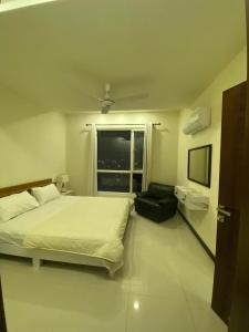a bedroom with a large bed and a window at 1 bed apartment infront of Centaurus in Islamabad
