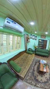 a living room with green furniture and a ceiling at TIKOO'S PEAK & PINE in Dalhousie