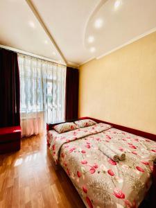 ein Schlafzimmer mit einem Bett und einem großen Fenster in der Unterkunft Kholodnaya gora in Kharkov