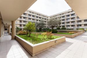 an apartment building with a garden in the courtyard at The Tropical Place in Milan