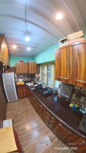 a large kitchen with wooden cabinets and a white refrigerator at TIKOO'S PEAK & PINE in Dalhousie