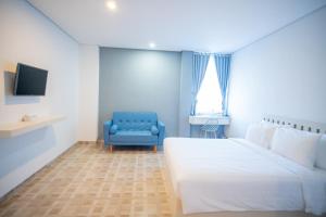 um quarto com uma cama e uma cadeira azul em Elephant Inn and Suite by Sajiwa em Bandar Lampung