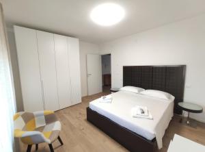 a bedroom with a large bed and a chair at Casa dei Demi in Pieve di Soligo