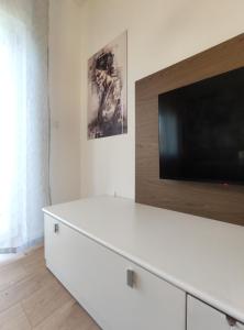 sala de estar con TV y tocador blanco en Casa dei Demi, en Pieve di Soligo