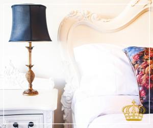 a bed with a lamp on a nightstand next to a bed with a pillow at The Old Crown Coaching Inn in Faringdon