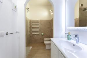 a white bathroom with a sink and a toilet at The Tropical Place in Milan