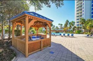 a wooden gazebo in a park with a pool at Coastal Oasis Retreat at The Palms of Destin! in Destin