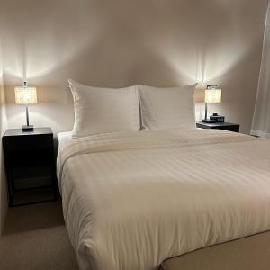 a large white bed with two nightstands and two lamps at Hotel Grand Canal in Delft