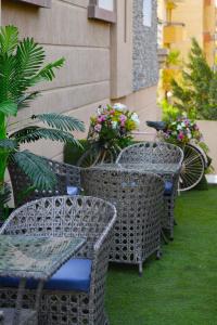 Arabella Premium Residence - New Cairo في القاهرة: صف من الكراسي والطاولات مع الزهور على الفناء