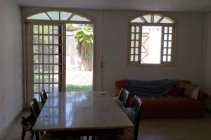 Casa com piscina aconchegante 300 m do mar في ريسيفي: غرفة معيشة مع طاولة وأريكة