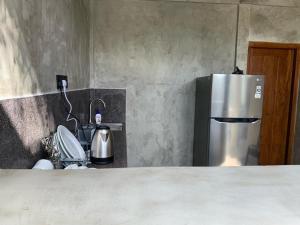 La cuisine est équipée d'un réfrigérateur en acier inoxydable et d'un évier. dans l'établissement Eton Villa, à Dikwella