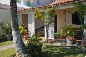 una casa con portico con alberi e piante di Recanto da Praia Linda a São Pedro da Aldeia