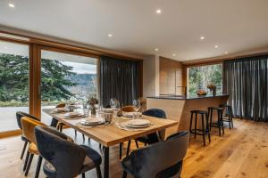 a dining room with a table and chairs and windows at Ambient Resort Bled in Bled