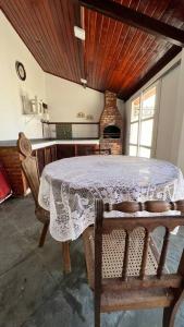uma cozinha com uma mesa com uma toalha de mesa branca em Recanto da Praia Linda em São Pedro da Aldeia