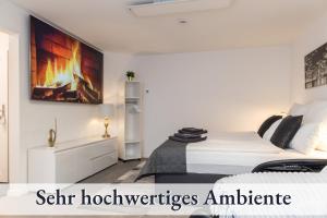 ビーベラハ・アン・デア・リスにあるRelaxApartment 1 Massagesessel SmartTV Kücheのベッドルーム1室(ベッド1台付)が備わります。壁には絵画が飾られています。