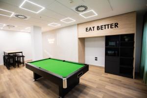 a pool table in a room with eat better sign at Micampus Burjassot Parque Residencia Universitaria in Burjassot