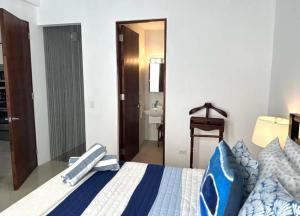 a bedroom with a blue and white bed and a bathroom at KASA The Lofts 304 in San Juan +14 photos