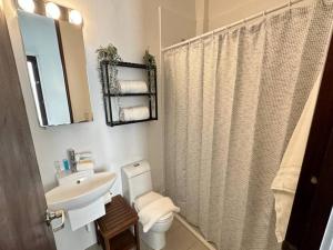 a bathroom with a sink and a toilet and a mirror at KASA The Lofts 304 in San Juan