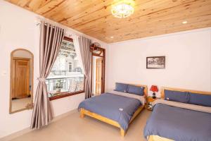 a bedroom with two beds and a window at LaMay Homestay in Da Lat