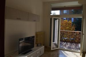 - un salon avec une télévision et une porte coulissante en verre dans l'établissement Appartamento Luna, à Ravenne