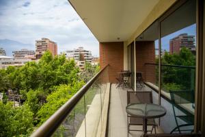 balcón con sillas y vistas a la ciudad en abba Presidente Suites Santiago, en Santiago