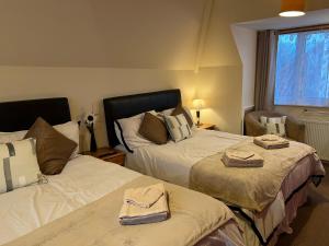 a bedroom with two beds and a window at The Singlecote Hotel in Lincolnshire +151 photos