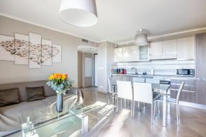a living room and kitchen with a glass table and chairs at LE MIDI 8 by ESTATES CANNES in Cannes