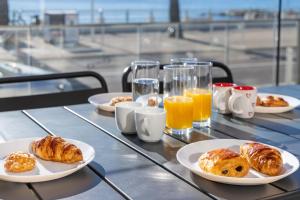 a table topped with plates of pastries and orange juice at LE MIDI 8 by ESTATES CANNES in Cannes