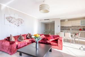 a living room with a red couch and a table at LE MIDI 8 by ESTATES CANNES in Cannes