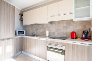 a kitchen with white cabinets and a red appliance at LE MIDI 8 by ESTATES CANNES in Cannes