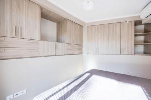 a room with a bed and wooden cabinets at LE MIDI 8 by ESTATES CANNES in Cannes