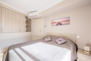 a bedroom with a bed with purple pillows on it at LE MIDI 8 by ESTATES CANNES in Cannes