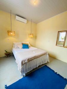 een slaapkamer met een groot bed en een blauw tapijt bij Casas na vila de Caraíva in Caraíva