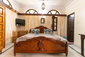 a bedroom with a wooden bed and a television at Kanhaia Haveli in Pushkar +101 photos