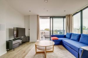 sala de estar con sofá azul y TV en Cozy in Camden Town/Balcony, en Londres