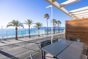 a table and chairs on a balcony with the beach at LE MIDI 8 by ESTATES CANNES in Cannes
