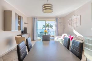 a dining room with a table and chairs and a living room at LE MIDI 8 by ESTATES CANNES in Cannes