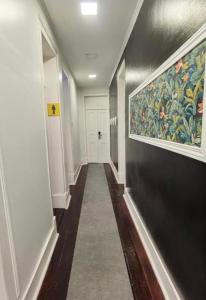 a hallway with a painting on the wall and a hallwayngthngthngthngthngth at Samps Hostel in Lisbon