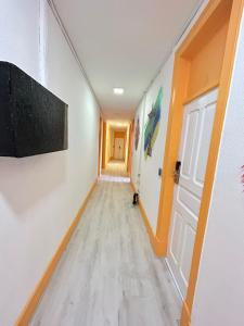 un corridoio vuoto con una parete bianca e una porta di Samps Hostel a Lisbona