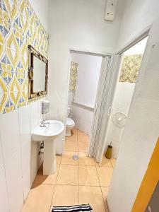 Samps Hostel في لشبونة: حمام مع حوض ومرحاض ومرآة