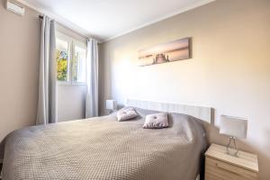 a white bedroom with a bed and a window at LE MIDI 8 by ESTATES CANNES in Cannes