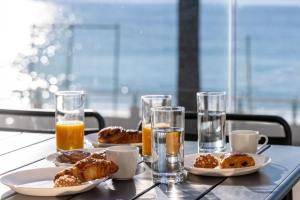 a table with plates of food and glasses of orange juice at LE MIDI 8 by ESTATES CANNES in Cannes