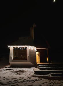 Una casa con luces de Navidad encendidas por la noche en Villa Luce en Kolašin