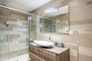 a bathroom with a sink and a glass shower at LE MIDI 8 by ESTATES CANNES in Cannes