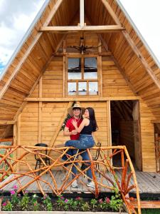 a man and woman sitting in front of a cabin at Los Nevados Ecolodge in Gigante