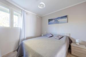a white bedroom with a bed and a window at LE MIDI 8 by ESTATES CANNES in Cannes
