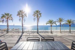 a view of the beach and palm trees at LE MIDI 8 by ESTATES CANNES in Cannes