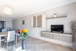 a living room with a dining table and a tv at LE MIDI 8 by ESTATES CANNES in Cannes
